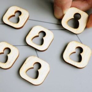 Picture of several wood pieces with a person cut out of the middle connected by lines representing the communication between the Delegate, the District Committee Members and General Service Representatives.